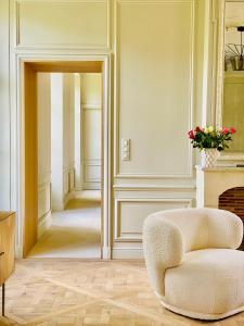 a living room with a chair and a fireplace at Bayeux, Normandy, Private Mansion, 17th-18th century, in the city in Bayeux