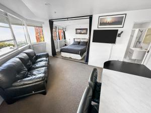 salon z kanapą i łóżkiem w obiekcie Whitaker Wish- Spacious, city based apartment with carpark w Auckland
