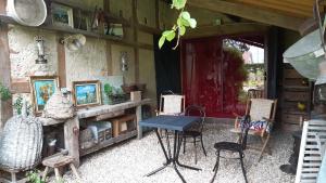 einen Tisch und Stühle vor einem Gebäude in der Unterkunft le buisson de la gariole ,chambre rhétaise in Aubigny-sur-Nère