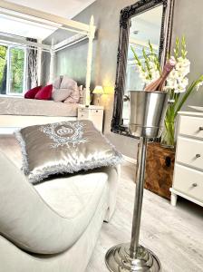 1 dormitorio con silla blanca y espejo en JB City Loft, en Hamburgo