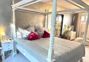 um quarto com uma cama de dossel branca com almofadas vermelhas em JB City Loft em Hamburgo