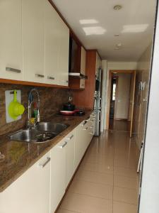 uma cozinha com armários brancos e um lavatório em 巴塞之家 em Montcada i Reixac