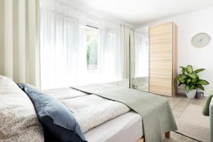 een slaapkamer met een bed en een groot raam bij Apart4me Scandi Apartment Geislingen zentral mit Parkplatz in Geislingen an der Steige