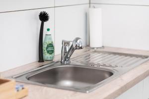 a sink in a kitchen with a brush on it at Apart4me Scandi Apartment Geislingen zentral mit Parkplatz in Geislingen an der Steige