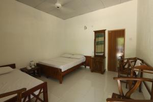 a bedroom with two beds and a table and chairs at Green Nest Yala in Hambantota