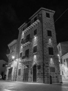 ein großes Backsteingebäude mit Lichtern in der Nacht in der Unterkunft La Torre in Santo Stefano di Camastra