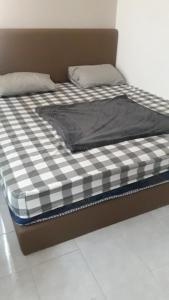 een bed met een zwart-wit geruite matras bij Apartemen Purimas - Sekai Unit in Surabaya