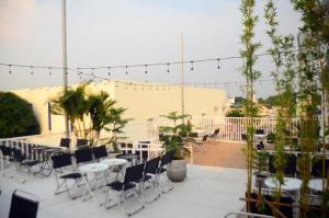 a rooftop patio with tables and chairs and plants at Hero Hostel & Billiards in Chau Doc