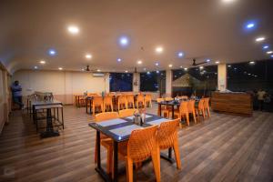 uma sala de jantar com mesas e cadeiras num restaurante em Unity Holiday Resort - Statue Of Unity em Kevadia