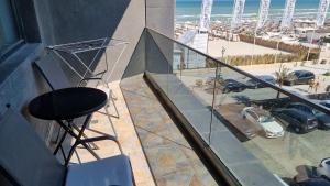 einen Hocker auf einem Balkon mit Meerblick in der Unterkunft Luxury New and Modern Apartments in Mamaia Nord – Năvodari