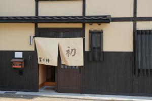 a sign is hanging over the door of a building at Kyoto-cocoro house in Kyoto