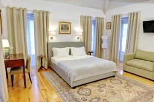 a bedroom with a bed and a desk and a chair at Casa das Laranjas in Porto