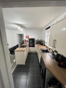a kitchen with white cabinets and a black tile floor at Luxury Spacious 2-Bed House in Brentwood Essex in Brentwood