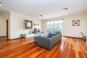 a living room with a couch and wooden floors at Bela Vista Valley in Calheta