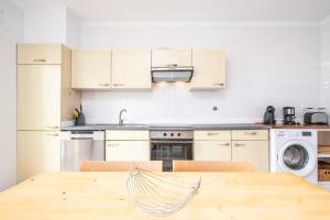 a kitchen with a wooden table and a kitchen with appliances at Bela Vista Valley in Calheta