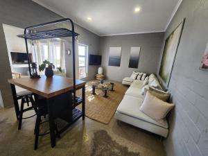 a living room with a table and a couch at Mirage-Beach Apartment in St Helena Bay
