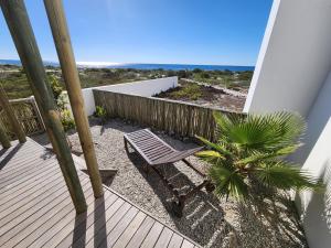 a wooden deck with a bench on the beach at Mirage-Beach Apartment in St Helena Bay