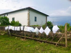 uma cerca com toalhas brancas em frente a uma casa em Un écrin dans la nature em Espelette