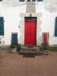uma porta vermelha do lado de um edifício em Un écrin dans la nature em Espelette