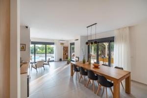 盧恩的住宿－BRAND NEW Luxury Villa Lun, 5-stars, 4 double bedrooms, pool，用餐室以及带木桌和椅子的客厅。