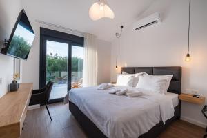盧恩的住宿－BRAND NEW Luxury Villa Lun, 5-stars, 4 double bedrooms, pool，一间卧室配有一张带书桌的床和窗户。