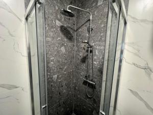 um chuveiro numa casa de banho com uma porta de vidro em Capital33 em Sarajevo