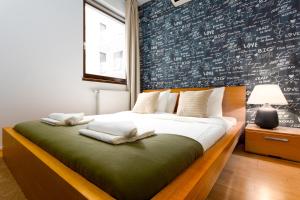 - une chambre avec un grand lit et un mur recouvert d'écriture dans l'établissement Urban Oasis with private parking, à Budapest