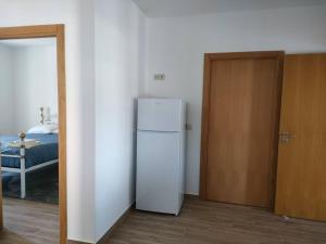 a white refrigerator in a room with a bedroom at Casa das Sapinhas (Ourém/Fátima) in Soutaria