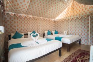 duas camas num quarto com cisnes em Unity Holiday Resort - Statue Of Unity em Kevadia