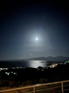 uma vista para o oceano à noite com a lua em Villa Michelangelo em Agios Nikolaos