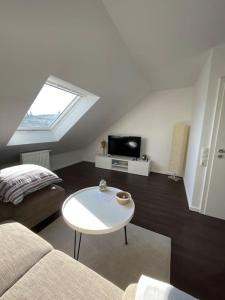 ein Wohnzimmer mit einem Sofa und einem Tisch in der Unterkunft Gemütliche Dachgeschosswohnung in Mönchengladbach in Mönchengladbach