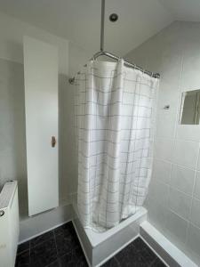 einen weißen Duschvorhang in einem weißen Badezimmer in der Unterkunft Gemütliche Dachgeschosswohnung in Mönchengladbach in Mönchengladbach
