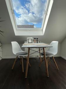 einen Tisch und zwei Stühle in einem Zimmer mit Fenster in der Unterkunft Gemütliche Dachgeschosswohnung in Mönchengladbach in Mönchengladbach