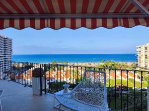 einen Balkon mit einem Stuhl und Meerblick in der Unterkunft Apartamento Los Cármenes in Playa de Gandia