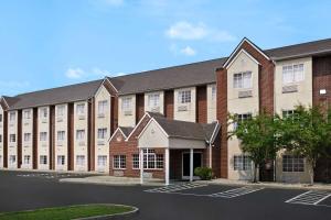 a large brick building with a parking lot at Microtel Inn & Suites by Wyndham Florence/Cincinnati Airpo in Florence