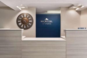 eine große Uhr an einer Wand in einer Lobby in der Unterkunft Microtel Inn & Suites by Wyndham Florence/Cincinnati Airpo in Florence