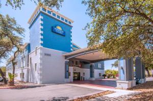 un edificio con un cartel en el costado en Days Inn & Suites by Wyndham San Antonio North/Stone Oak, en San Antonio