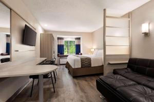 フローレンスにあるMicrotel Inn & Suites by Wyndham Florence/Cincinnati Airpoのベッドとソファ付きのホテルルーム