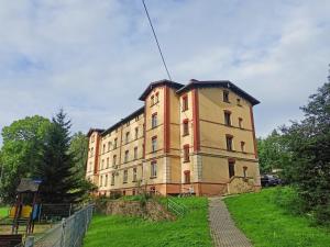 un edificio en la cima de una colina con césped en Apartament Celebrity en Leśna