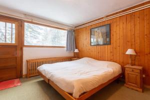 una camera con un grande letto e una finestra di Chalet Robaumont - Grand chalet familial proche du centre et des pistes a Courchevel