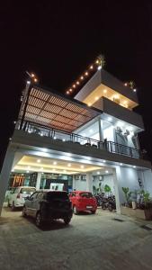 um edifício com carros estacionados num parque de estacionamento à noite em Dawala Hotel em Sudiang