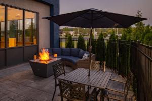 une terrasse avec un canapé, un parasol et une table dans l'établissement Hampton Inn Seekonk, à Seekonk