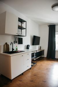 uma cozinha com armários brancos e uma bancada em Macao Apartmani em Vinkovci