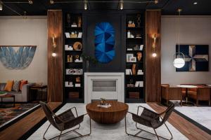 un soggiorno con sedie, tavolo e camino di The Alloy, a DoubleTree by Hilton - Valley Forge a King of Prussia