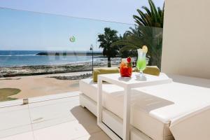 ein Wohnzimmer mit einem Tisch und Meerblick in der Unterkunft HD Beach Resort in Costa Teguise