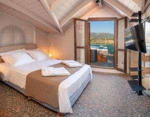 a bedroom with a bed and a flat screen tv at Pink Panther Maisonette Suite in Argostoli