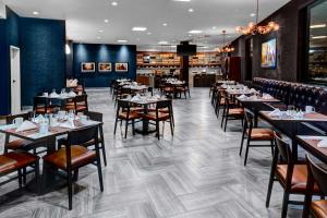 阿林顿南阿林顿达拉斯/沃思堡国际机场希尔顿逸林酒店的一间在房间内配有桌椅的餐厅