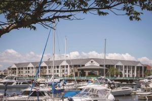 een groep boten aangemeerd voor een groot gebouw bij DoubleTree by Hilton Racine Harbourwalk in Racine