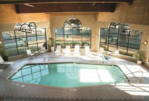 una piscina en un edificio con sillas y mesa en DoubleTree by Hilton Racine Harbourwalk, en Racine