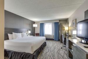a hotel room with a large bed and a flat screen tv at DoubleTree by Hilton Racine Harbourwalk in Racine
